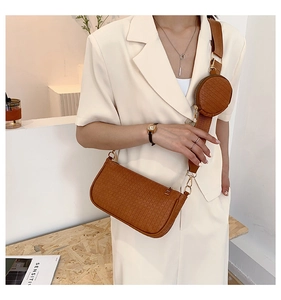 Detail of caramel embossed underarm bag with a round coin pouch and wide strap