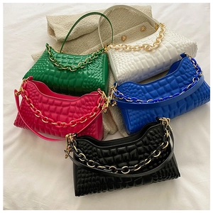 Detail of colorblock baguette bags with crocodile texture and gold chunky chain straps