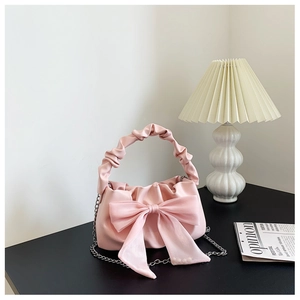 Détail du sac à main rose avec grand nœud en résille, poignée froncée et chaîne argenté