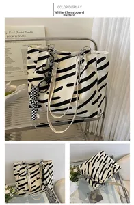 Detail view of canvas tote with black abstract stripes, silver chain, and checkered bow