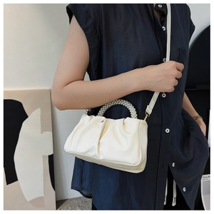 Detail showing white pleated cloud bag with faux pearl handle and detachable strap
