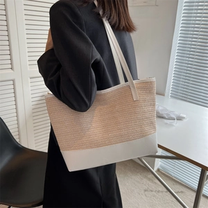 Large straw tote bag with white leather straps and wave texture for beach vacations