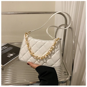 Détail du sac à main matelassé blanc avec poignée en acrylique et maillons dorés
