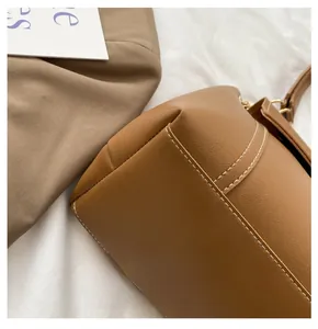 Close-up of brown faux leather bag featuring white contrast stitching and fine craftsmanship
