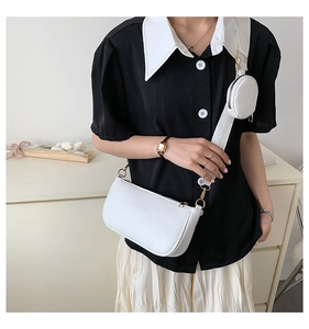 Detailed view of white woven shoulder bag with wide strap and matching round coin purse