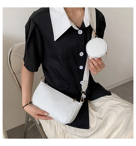White woven leather underarm bag with a round coin pouch shown on a model