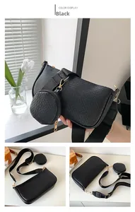 Close-up of black textured underarm bag featuring a small round coin purse and gold hardware