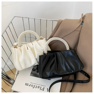 Detailed view of pleated cloud bags with elegant pearl handles and detachable shoulder straps