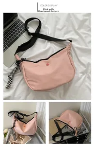 Pink crescent nylon bag with adjustable black strap and checkerboard charm detail