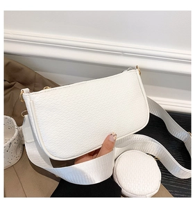 Detailed macro view of white textured underarm bag with matching round coin purse detail