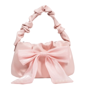 Sac bandoulière rose avec grand nœud en mousseline et poignée plissée sur fond blanc