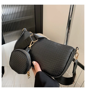 Close-up of black diamond-weave underarm bag with gold hardware and small round coin pouch