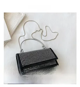 Detail view of black square bag featuring silver studs and metallic handle