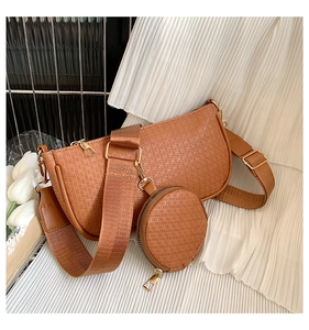 Detail of caramel underarm bag with embossed texture, wide strap and round coin purse
