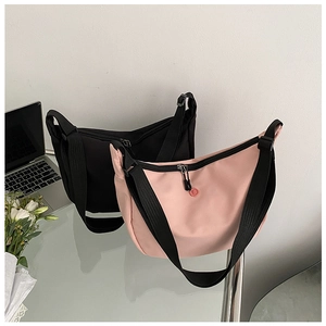 Close-up of pink and black nylon crescent crossbody bags with adjustable wide shoulder straps