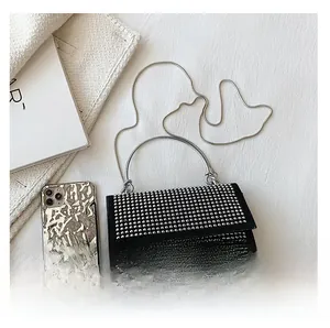 Detail view of mini rhinestone crossbody bag with silver chain strap and phone size comparison