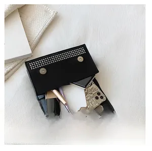Top view of black rhinestone clutch interior showing capacity for makeup and phone