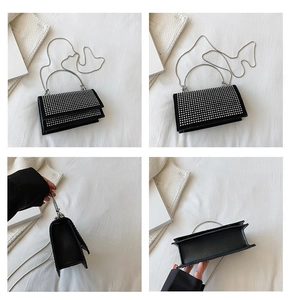 Detail view of black square bag with silver rivets, ring handle and metal chain strap
