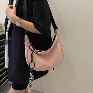 Pink crescent crossbody bag in durable oxford fabric with black chain and checkerboard bow