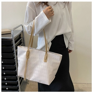 Detail of white tote bag with woven rhombus pattern and beige shoulder strap