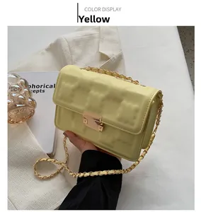 Detail of creamy yellow chain bag featuring matrix embossed texture and gold clasp