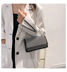 Close-up of black crossbody bag featuring sparkling silver rhinestones and chain strap
