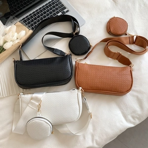 Three minimalist textured underarm bags in black, brown, and white with small coin purses