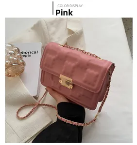 Detail of pink quilted shoulder bag with gold metal buckle and elegant leather chain strap