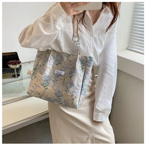 Detail of vintage tote bag with blue hydrangea floral pattern and chain leather strap