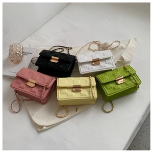 Detailed view of square crossbody bags with embossed bear patterns and metal chain straps