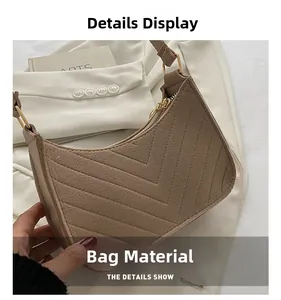 Close-up of brown crescent bag with fine V-shaped quilting and golden zipper details