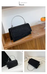Close-up of black rhinestone square handbag with silver metal ring handles and chain