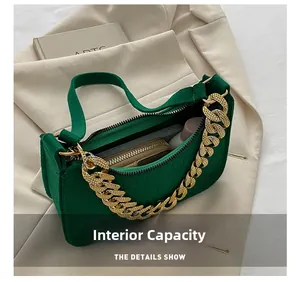 Detail showing inner capacity of dark green croc-embossed leather bag with gold chain