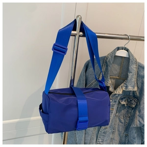 Dettaglio borsa a cilindro in nylon blu brillante con ampia tracolla regolabile sport