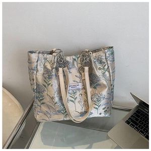 Close-up of vintage floral jacquard tote bag with leather handles and metal chain detail