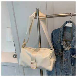 Detail of cream nylon crossbody bag with wide adjustable strap and plastic buckle