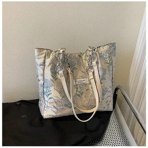 Detail of floral jacquard tote bag with leather handles and silver chain strap
