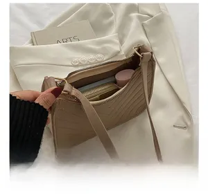 Detail showing the internal storage capacity of the beige quilted crescent shoulder bag