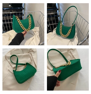 Detail view of green crocodile pattern shoulder bag with chunky gold chain decoration