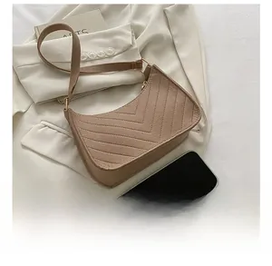 Brown suede hobo bag with V-shaped quilting shown next to a smartphone for size scale