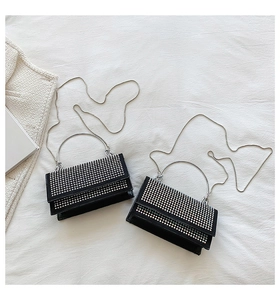 Close-up of black rhinestone mini bags with silver chain straps and ring handles