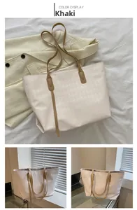 Detail of khaki tote bag featuring diamond quilted texture and long shoulder straps