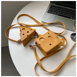 Mini sacs bandoulière créatifs en forme de fromage, modèles triangle et carré sur bureau