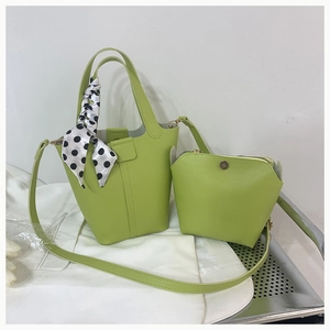 Detail view of grass green bucket bag with polka dot scarf and matching zipper pouch