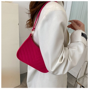 Close-up of hot pink crescent bag with V-quilted pattern and golden hardware details