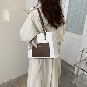 Fashionable checkered tote bag with brown leather pocket and decorative scarf detail