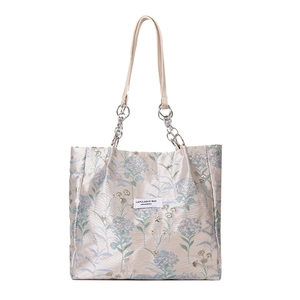 Floral embroidered tote bag with silver chain handles in off-white minimalist style