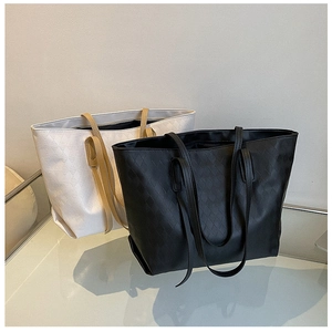 Detail shot of black and beige woven texture tote bags on a reflective surface