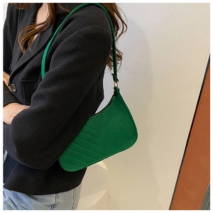 Model wearing green quilted crescent underarm bag with a stylish black blazer