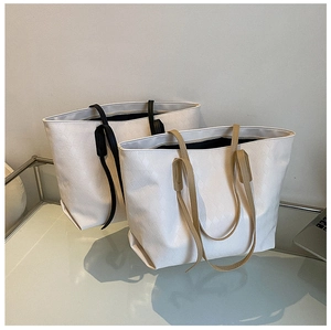 Detail view of large tote bags with diamond quilted pattern and dual-color handles